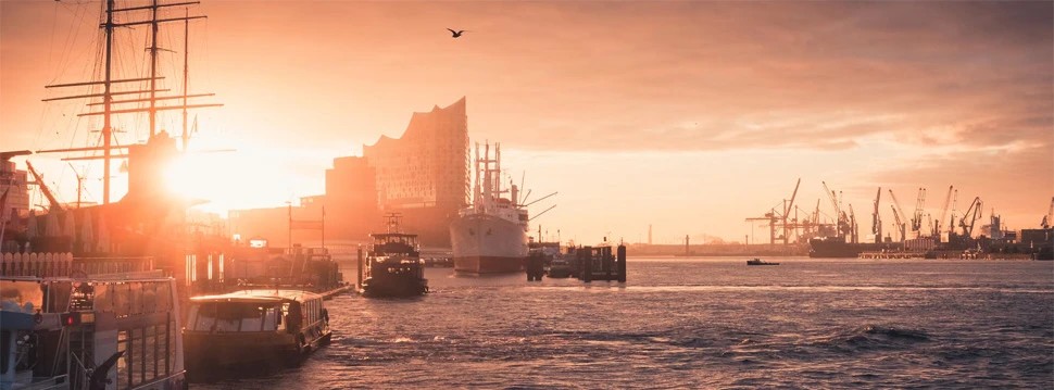 Hamburger Hafen mit der Elbphilharmonie und der Speicherstadt bei Sonnenaufgang