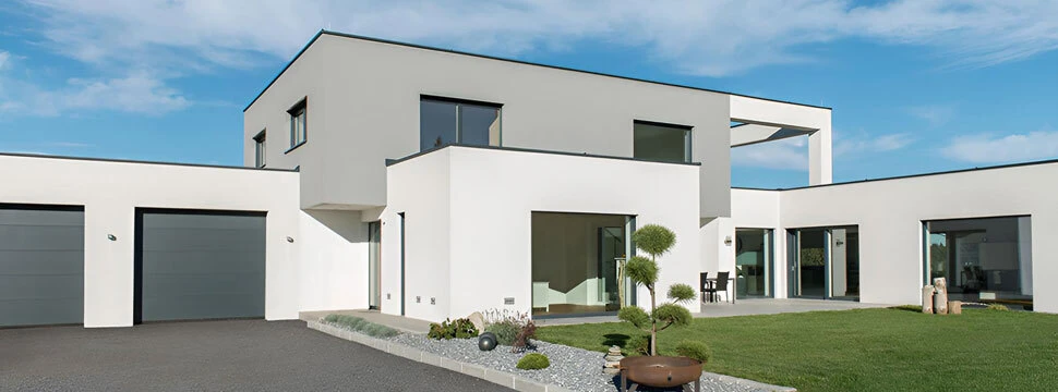 Modernes Architektenhaus mit Garage, Glasfronten und gepflegtem Garten.