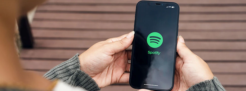 Hände halten ein Handy mit Spotify App