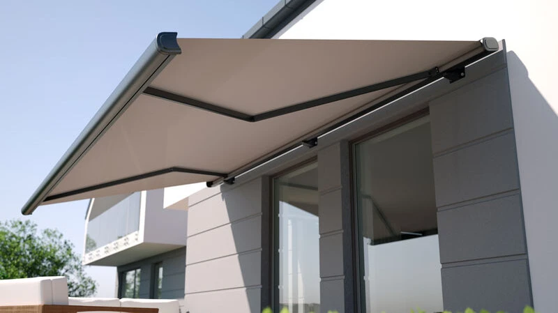 Eine ausgefahrene Markise verwandelt die Terrasse in einen schattigen Rückzugsort und schützt zugleich Möbel und Bodenbeläge vor dem Ausbleichen