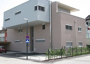 Modernes Wohnhaus mit kubistischer Architektur, Flachdach und Carport in städtischer Umgebung.