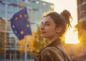 Auch junge Menschen können sich schon politisch engagieren Junge Frau vor Bürogebäuden mit der Flagge der Europäischen Union