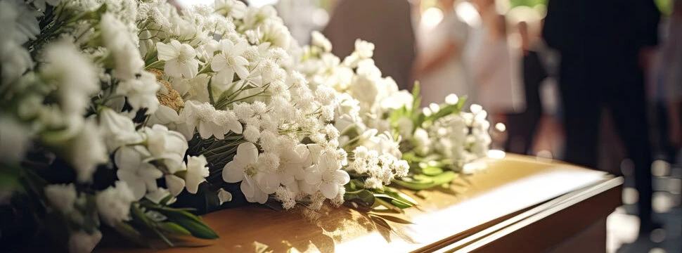 Bestattungsvorsorge in Schladming und Gröbming | weiße Blumen auf Sarg