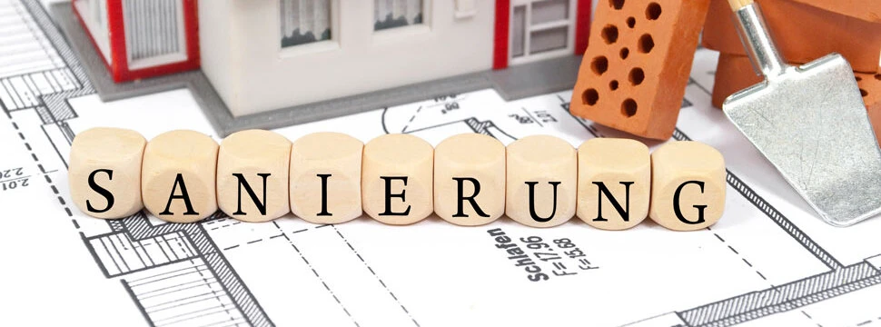 Altbausanierung - Bauplan mit Ziegelsteinen und Sanierung