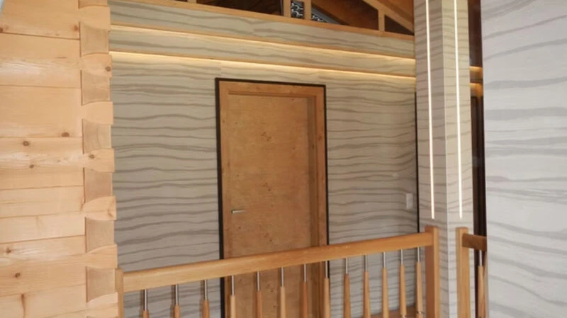 Präzise tapezierte Wände mit modernem Wellenmuster in einem Innenraum mit Holzdetails - Neumayr Günter GmbH