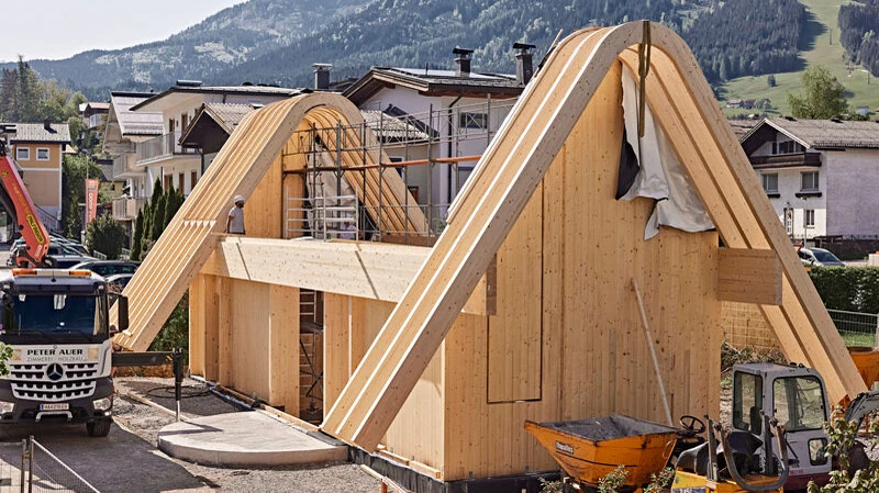 Außergewöhnliche Architektur trifft auf handwerkliche Präzision – geschwungene Leimbinder aus Holz zeigen, welche gestalterischen Möglichkeiten moderner Holzbau bietet.