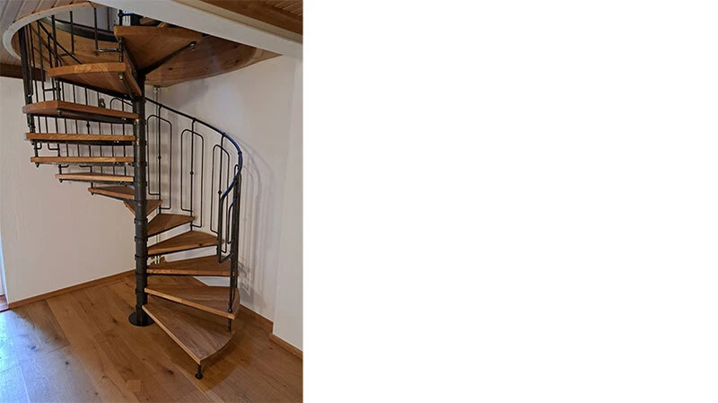 Geschmiedete Spindeltreppe mit massiven Eichenholzstufen – moderne Handwerkskunst aus Stahl und Holz, filigran verarbeitet mit charaktervollem Geländer und zeitlos-eleganter.