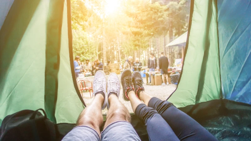 Festival Must-Have: Zelt und Schlafsack Blick aus dem Schlafsack auf Menschen im Wald